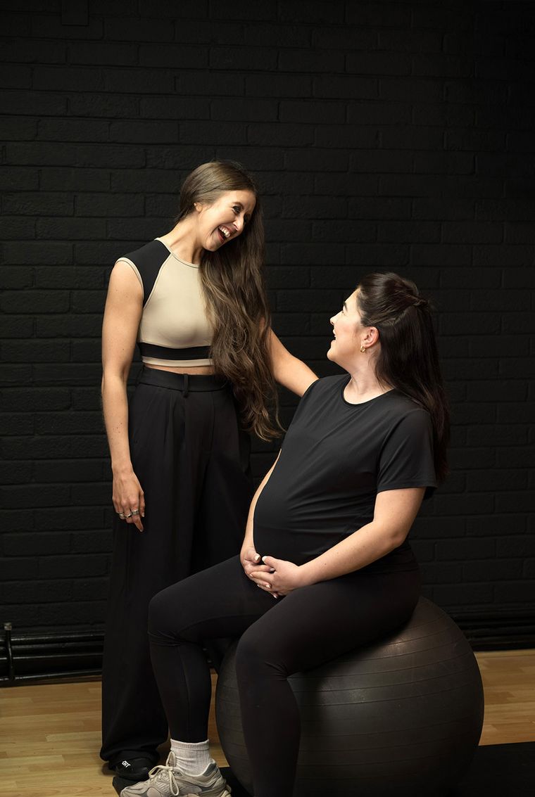 Elin Wyn talking with a pregnant client seated on an exercise ball