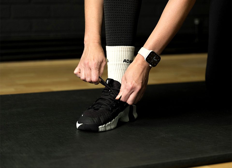 A client lacing a training shoe before a one-to-one session